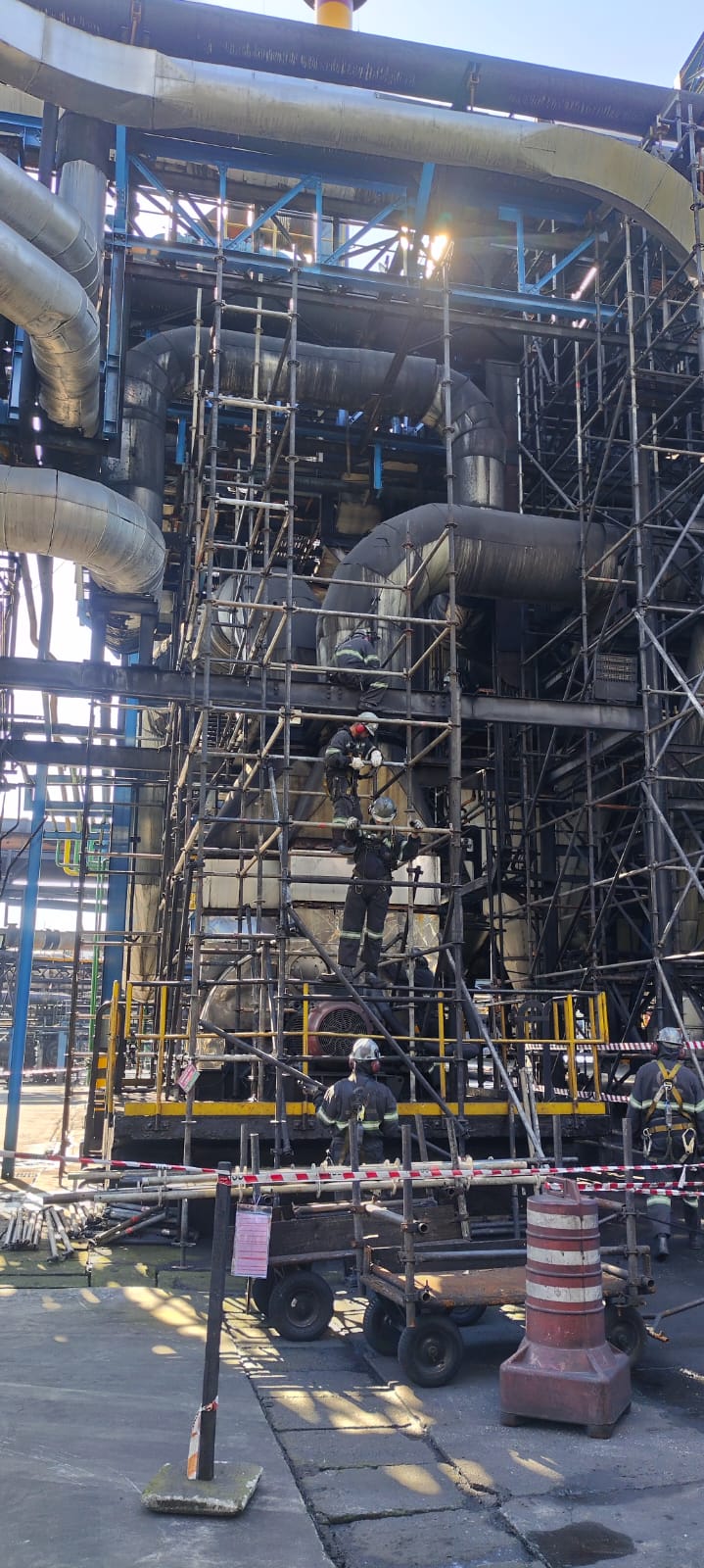 Equipe de montagem em ação sobre andaime industrial